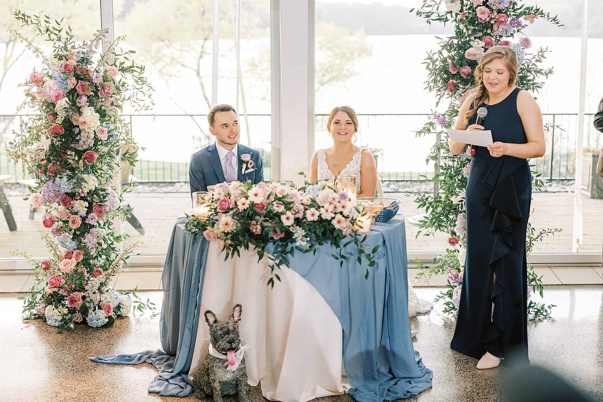 Bride and groom listen to their maid of honor give a speech during their Lake House Inn wedding reception