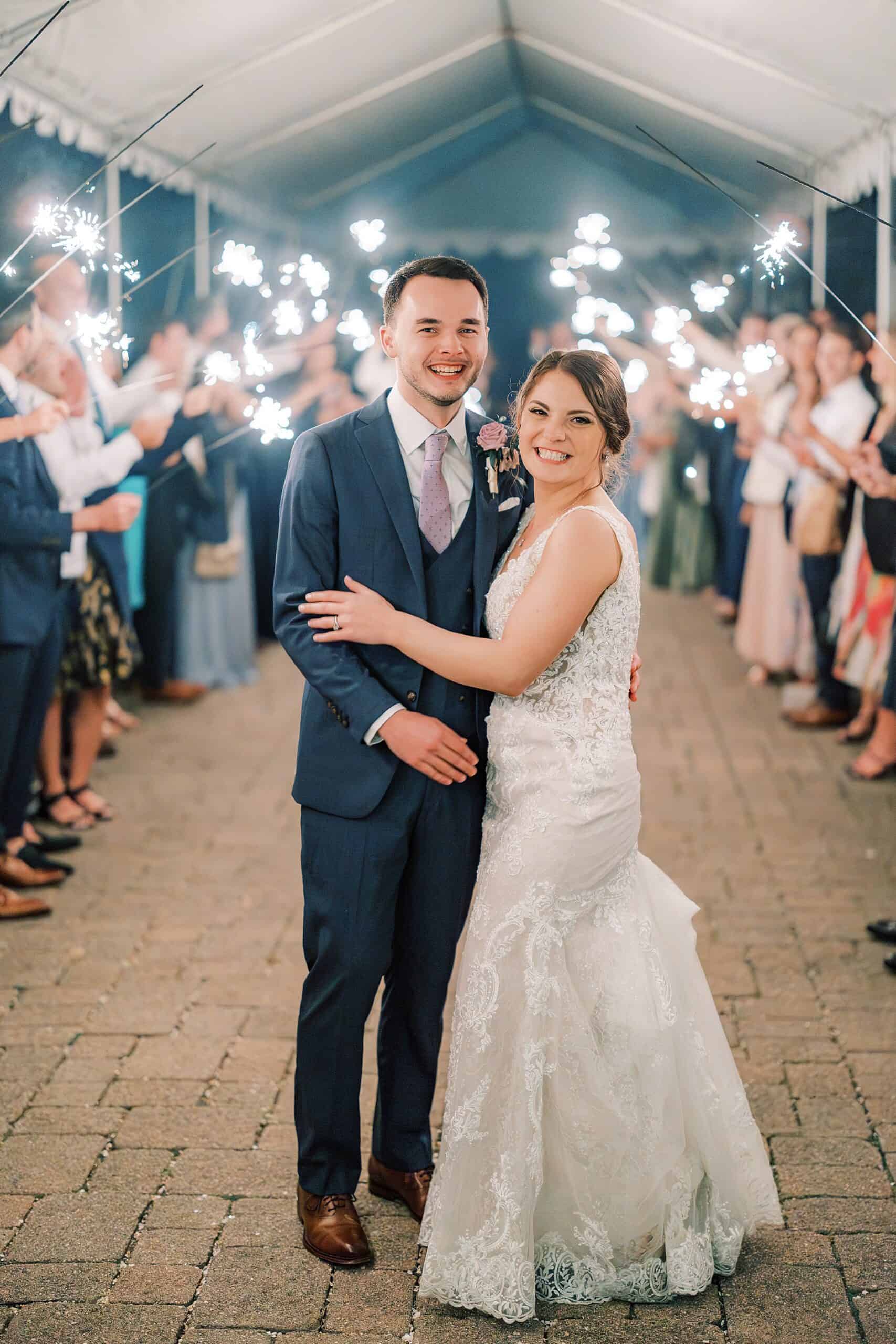 bride and groom smile during their Lake House Inn wedding reception during their sparkler send off