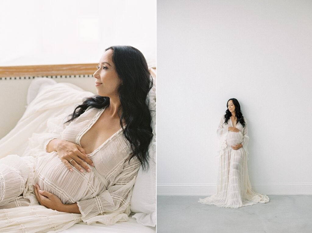 A film photography image of a mother in a white, natural light photo studio in the suburbs of Philadelphia. She sits reclined holding her pregnant belly and smiling sweetly 