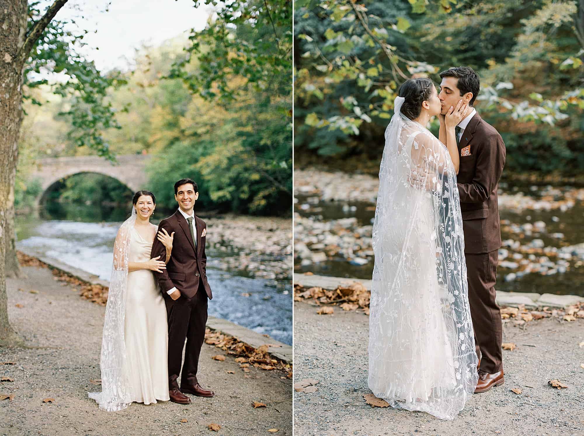 Two side-by-side images of a bride and groom enjoying their wedding day by a picturesque stream. On the left, the couple stands close together, sharing a tender moment with a stone bridge and autumn leaves in the background. The bride wears a satin gown with a floral lace veil, and the groom is dressed in a dark brown suit. 