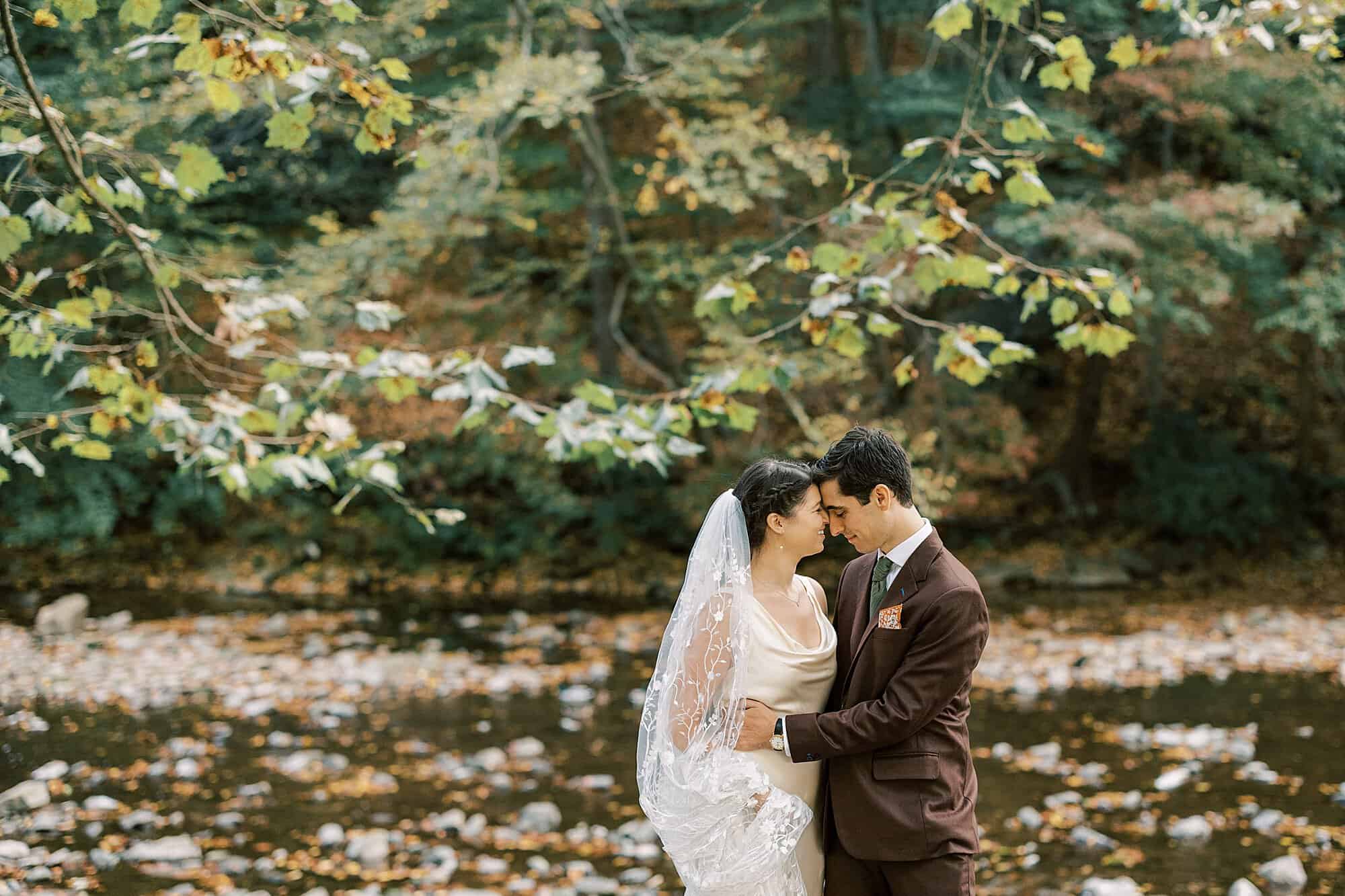 a couple shares a tender moment with autumn leaves in the background during their Valley Green Inn wedding photo session