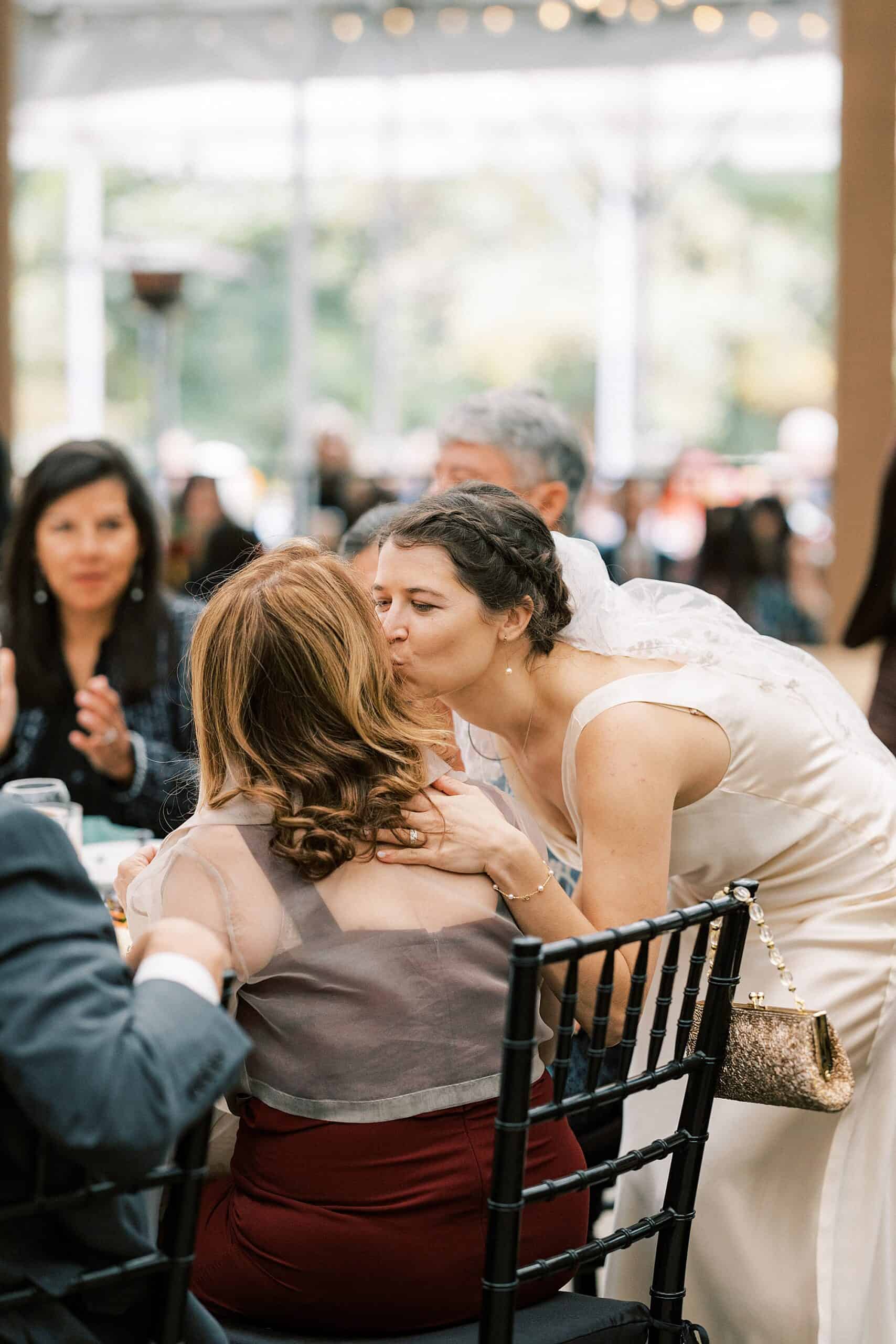 a bride kisses her mother on the cheek 