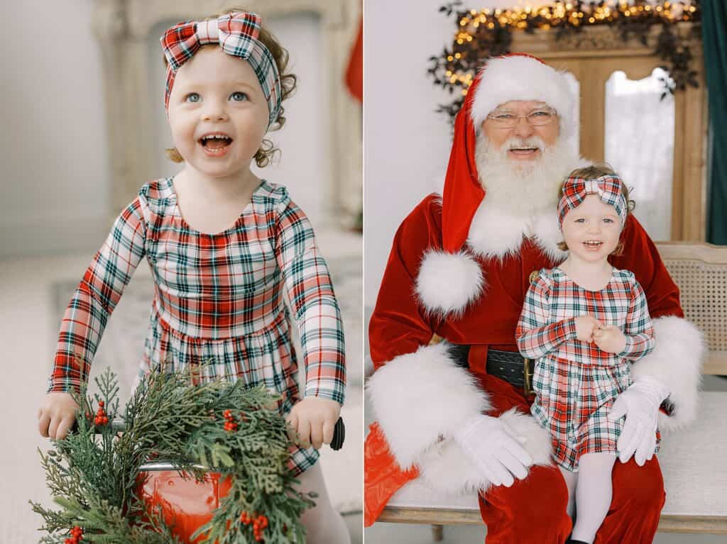 A 2 year old girl in a plaid Christmas dress smiles at the camera as she sits on Santa's lap during Samantha Jay Photography's Santa Photo Sessions at her studio in Aston PA