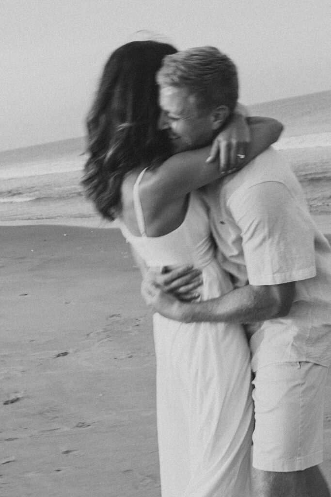 Intimate embrace captured on black and white film at Delaware beach engagement photoshoot
