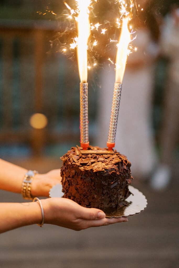 Chocolate groom's cake with sparkler candles held up during the rehearsal dinner celebration at Skytop Lodge, Pennsylvania