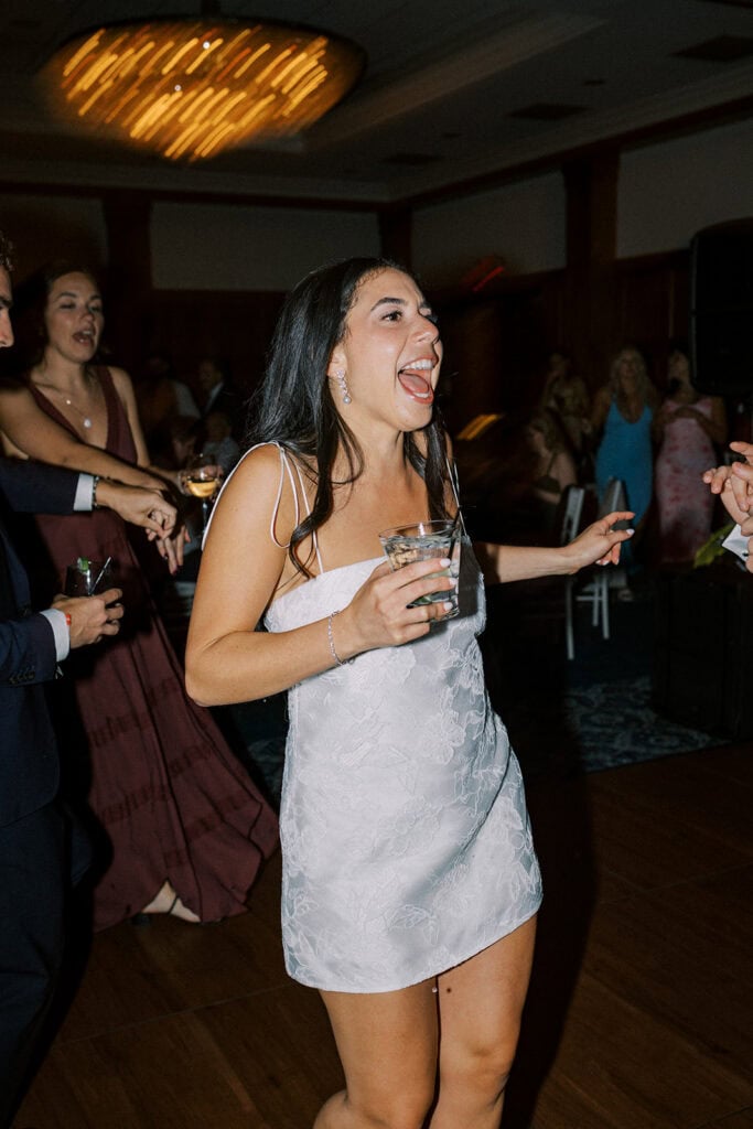Bride in reception dress dancing and laughing on the wood floor of the Skytop Lodge ballroom during her wedding reception