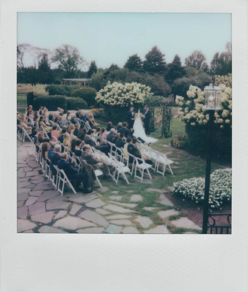 Polaroid of an outdoor garden ceremony at Skytop Lodge with white folding chairs and blooming hydrangeas in Skytop, Pennsylvania