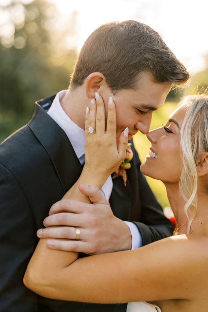 Close-up portrait of bride and groom nearly kissing at golden hour, bride's cushion cut diamond engagement ring and groom's gold wedding band visible, Tyler Arboretum fall wedding Media PA