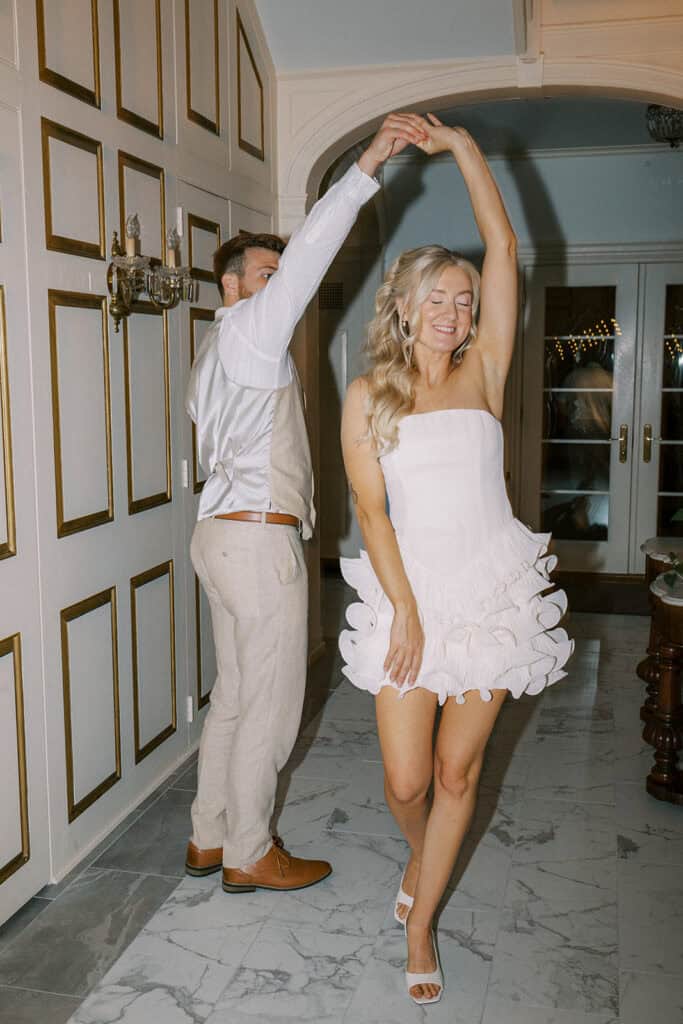 Bride in white ruffle reception dress being twirled by groom inside Drumore Estate Georgian mansion at summer wedding in Lancaster PA