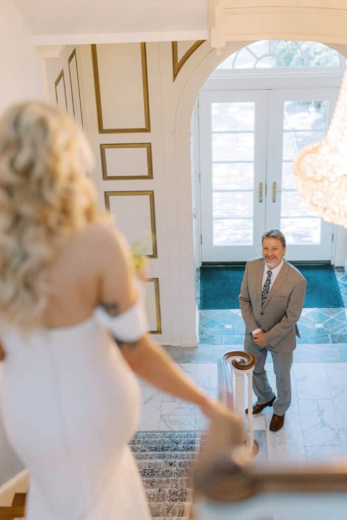 Father of the bride seeing his daughter for the first time on wedding day inside Drumore Estate Georgian mansion staircase in Pequea PA