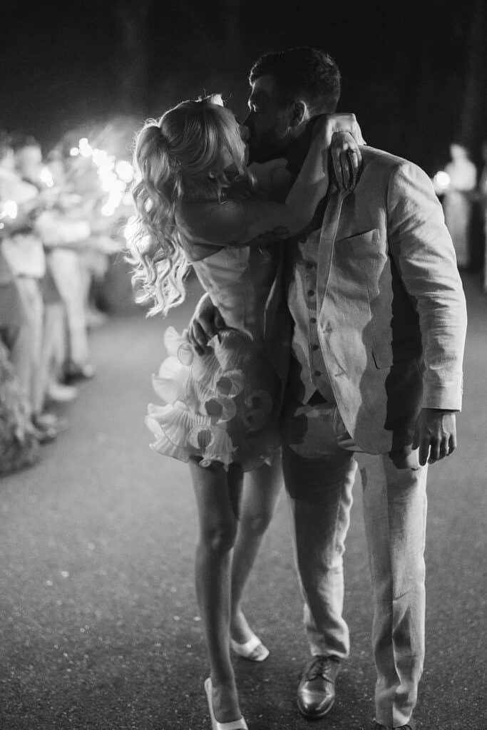 Black and white photo of bride and groom kissing during sparkler sendoff at Drumore Estate summer wedding Lancaster County PA