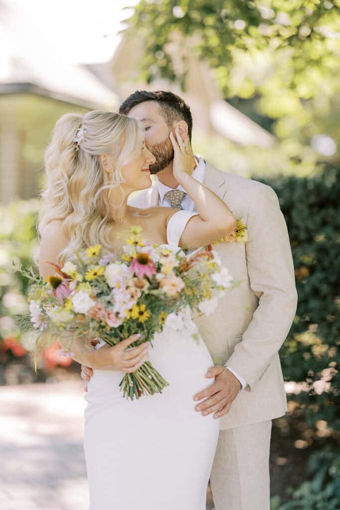 Intimate bride and groom portrait at Drumore Estate summer wedding with bright wildflower bouquet featuring pink coneflowers and yellow daisies