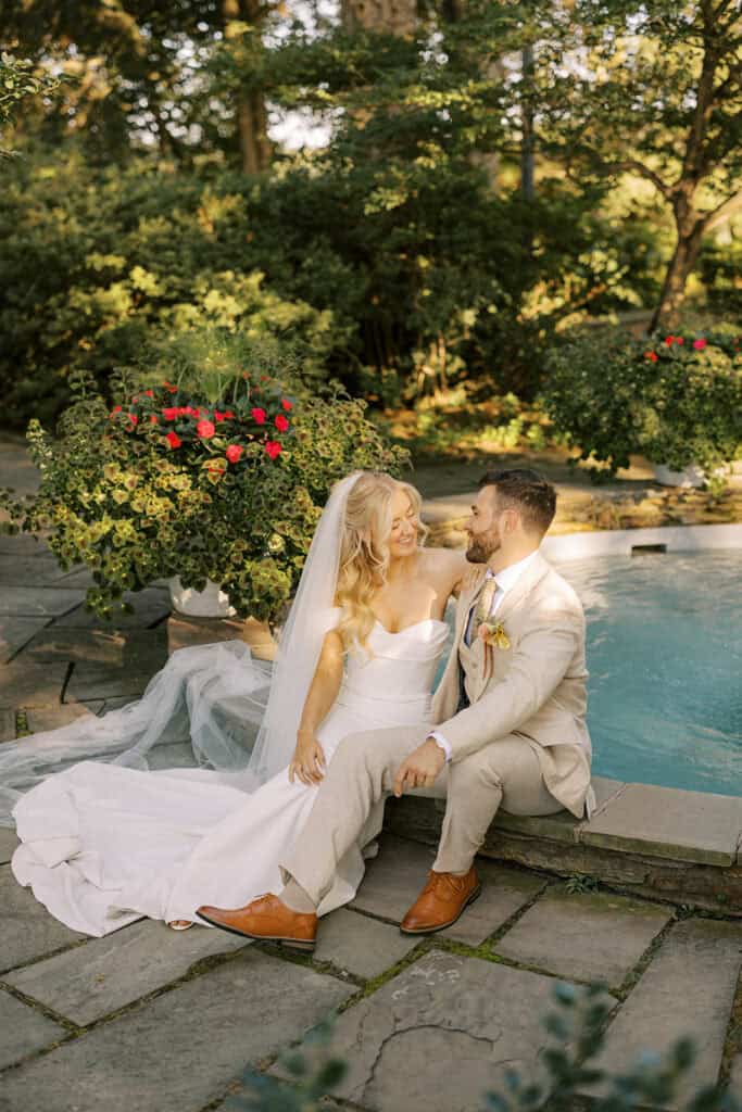 Bride and groom sitting together laughing by fountain at Drumore Estate outdoor wedding venue in Pequea Lancaster County Pennsylvania