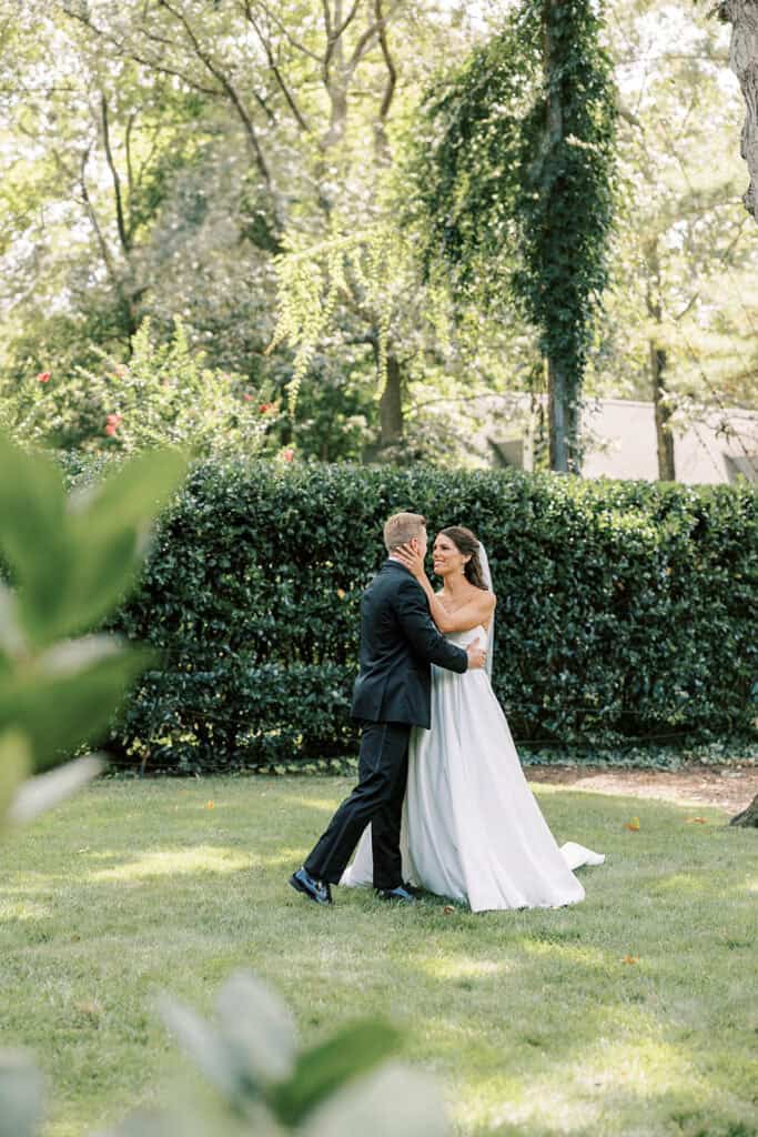 Bride and groom embracing during first look in garden setting at Rehoboth Beach Delaware wedding, Samantha Jay Photo