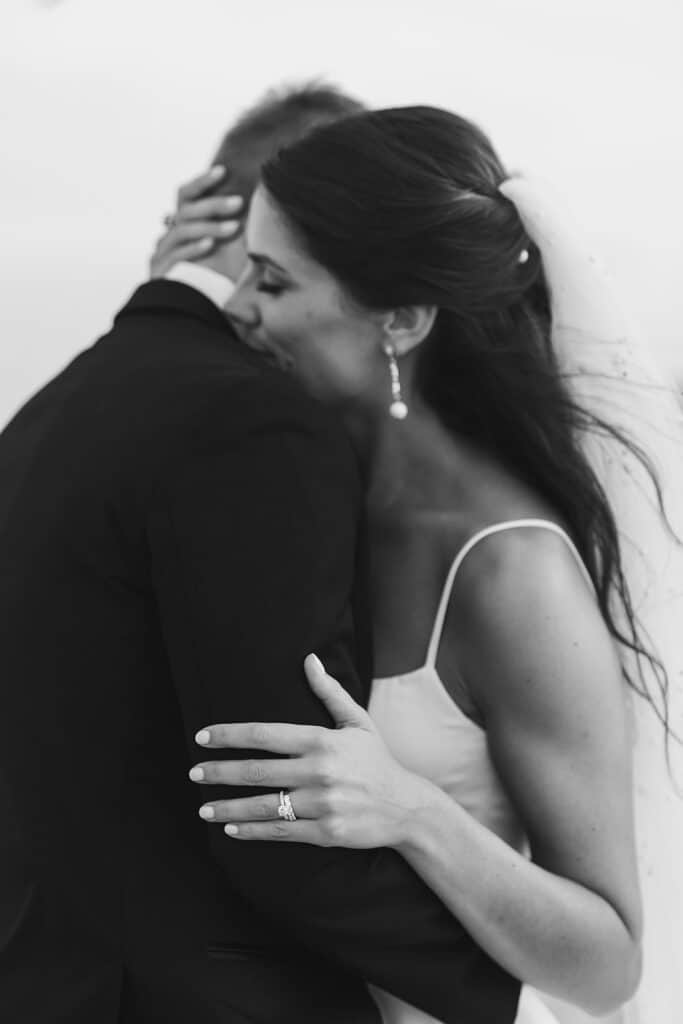 Black and white intimate portrait of bride and groom hugging during Rehoboth Beach wedding, Delaware wedding photography by Samantha Jay Photo