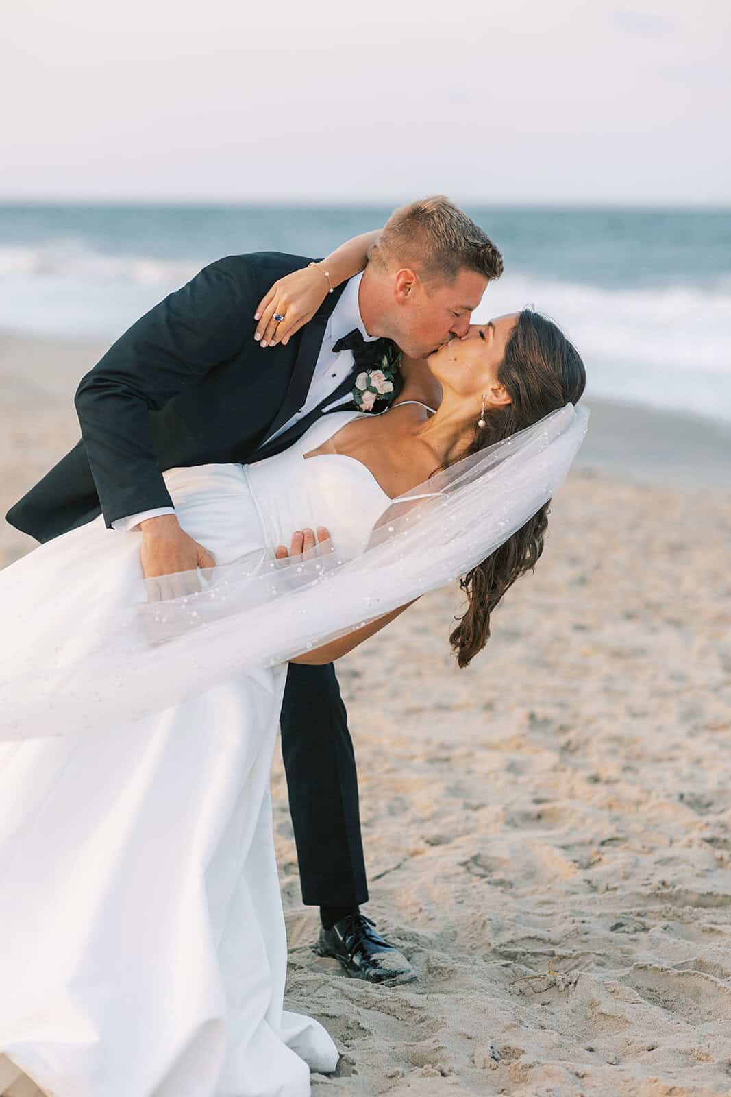 Groom dipping bride for a kiss during Rehoboth Beach wedding portraits, Delaware wedding photography by Samantha Jay Photo