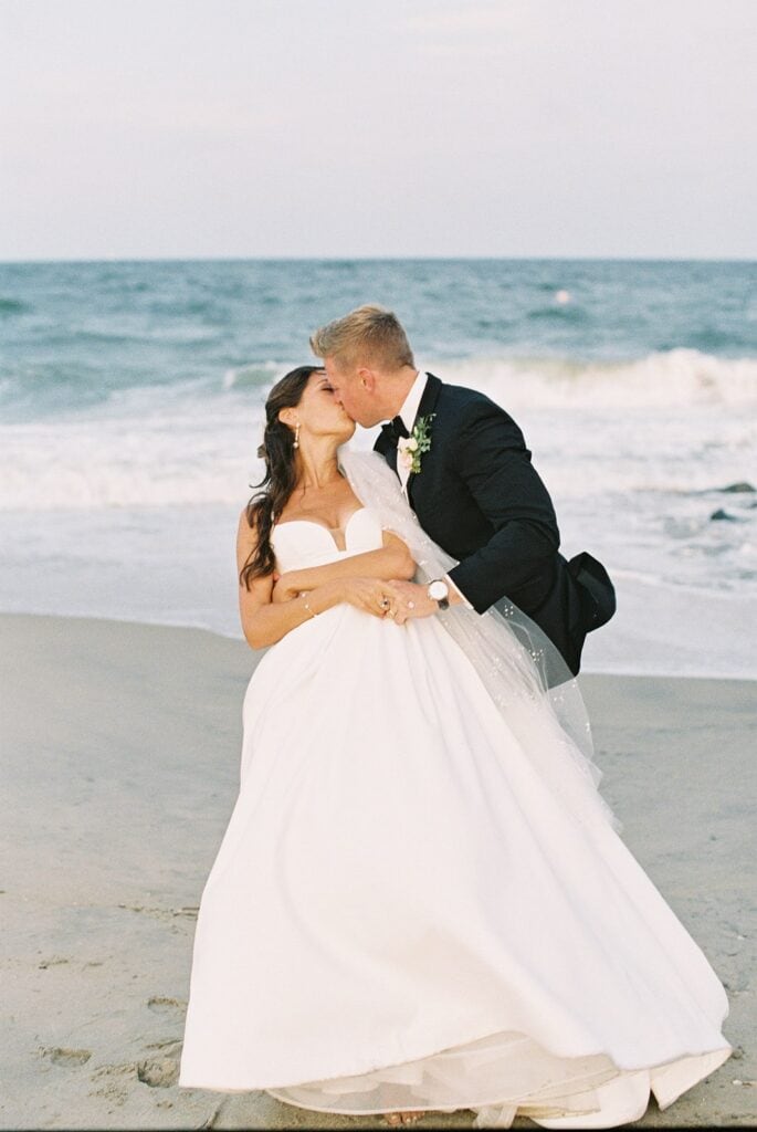 Bride and groom kissing on the beach at Rehoboth Beach, Delaware, captured on film by Samantha Jay Photo