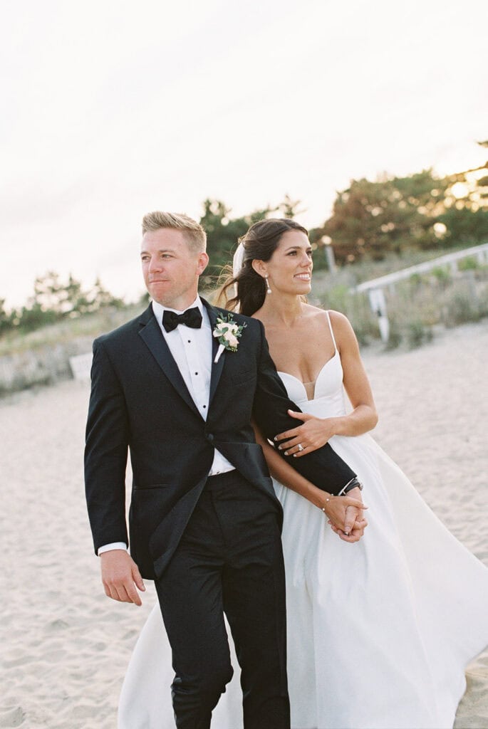 Bride and groom walking along Rehoboth Beach at golden hour, film wedding photography by Samantha Jay Photo