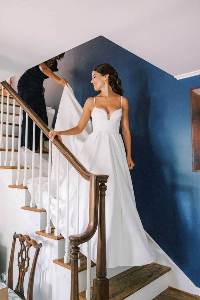 Bride descending staircase in wedding gown during getting ready at Rehoboth Beach Delaware home, photographed by Samantha Jay Photo