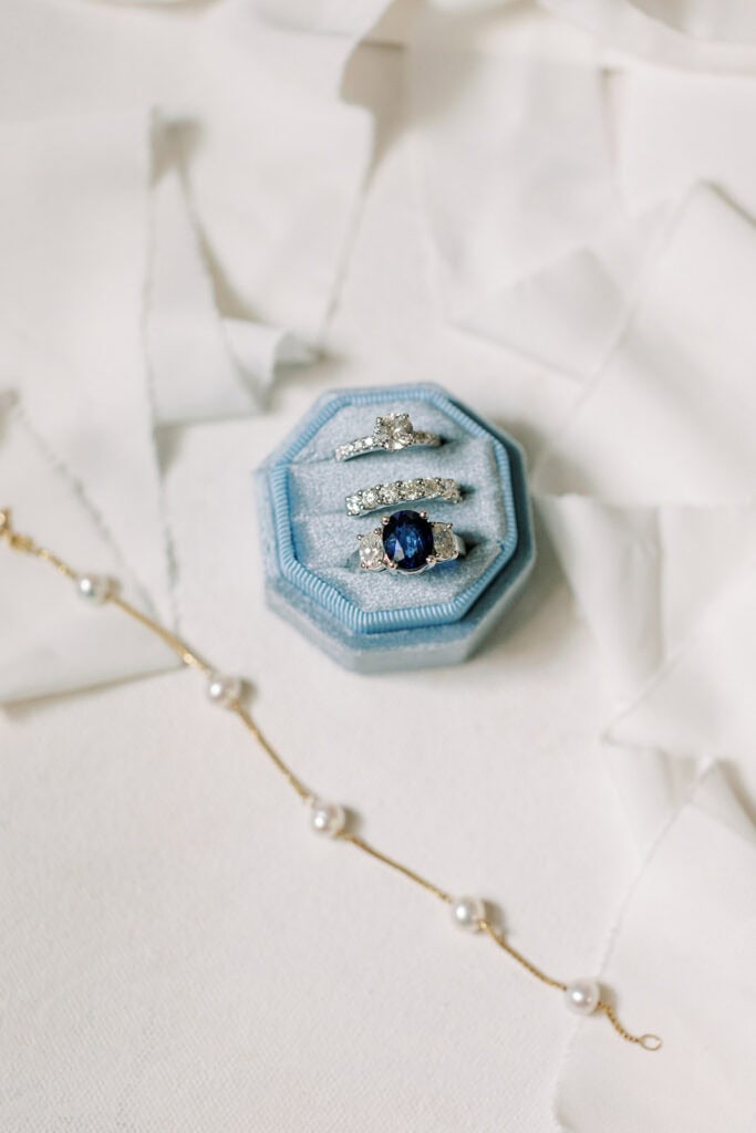Sapphire engagement ring and diamond wedding bands in blue velvet ring box, Rehoboth Beach wedding details photographed by Samantha Jay Photo