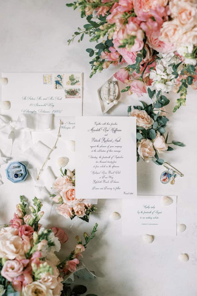 Rehoboth Beach wedding flat lay with pink garden roses, blush florals, invitation suite, and bridal jewelry, Samantha Jay Photo