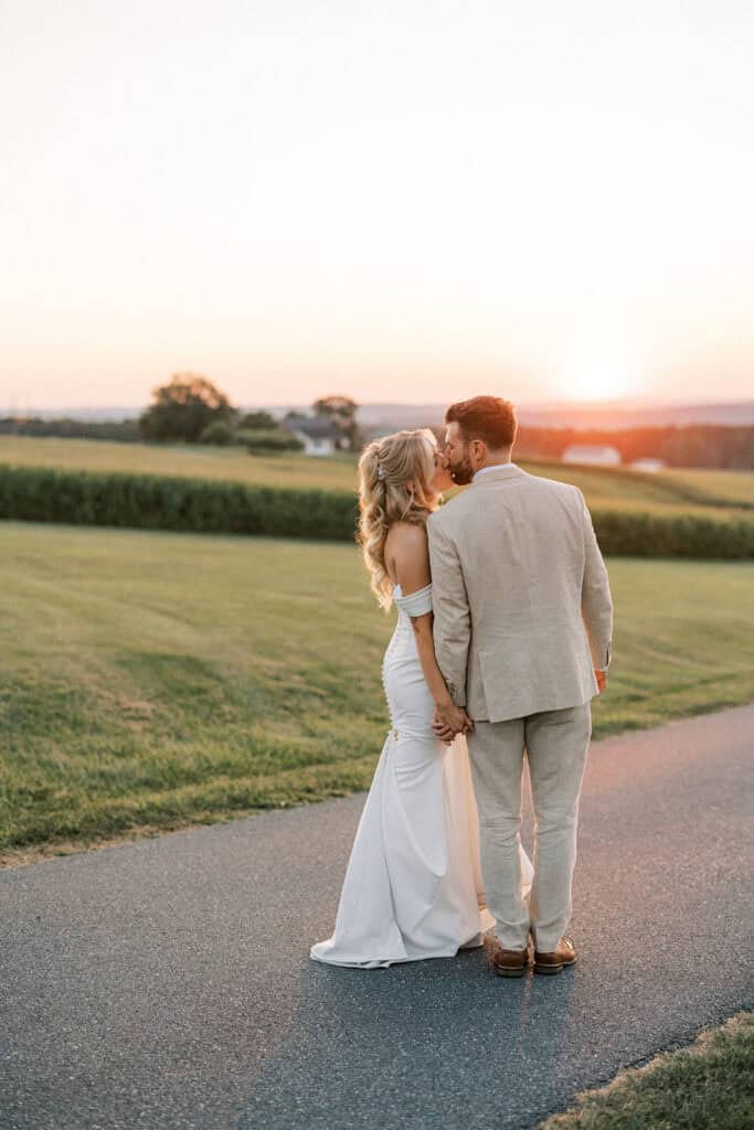 Bride and groom kissing at sunset on country road at Drumore Estate wedding in Pequea Lancaster County Pennsylvania