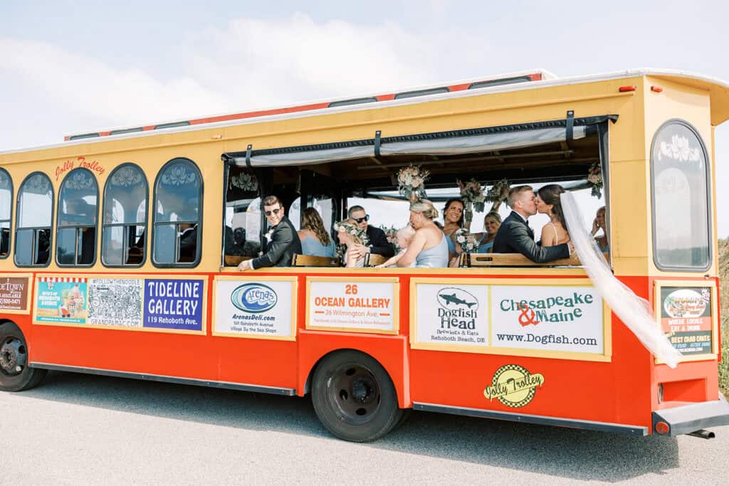Wedding party riding the Jolly Trolley in Rehoboth Beach Delaware after beach ceremony at Henlopen Acres Beach Club