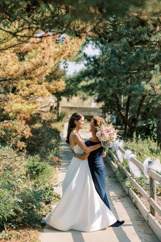 Bride and mother of the bride embracing before ceremony at Henlopen Acres Beach Club, Rehoboth Beach Delaware wedding
