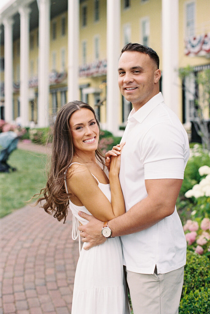 Cape May engagement session at Congress Hall with Carolyn and Zach in coordinated white outfits among summer hydrangea gardens
